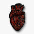 Decorative handmade Heart brooch pin with red and black color on a white background.
