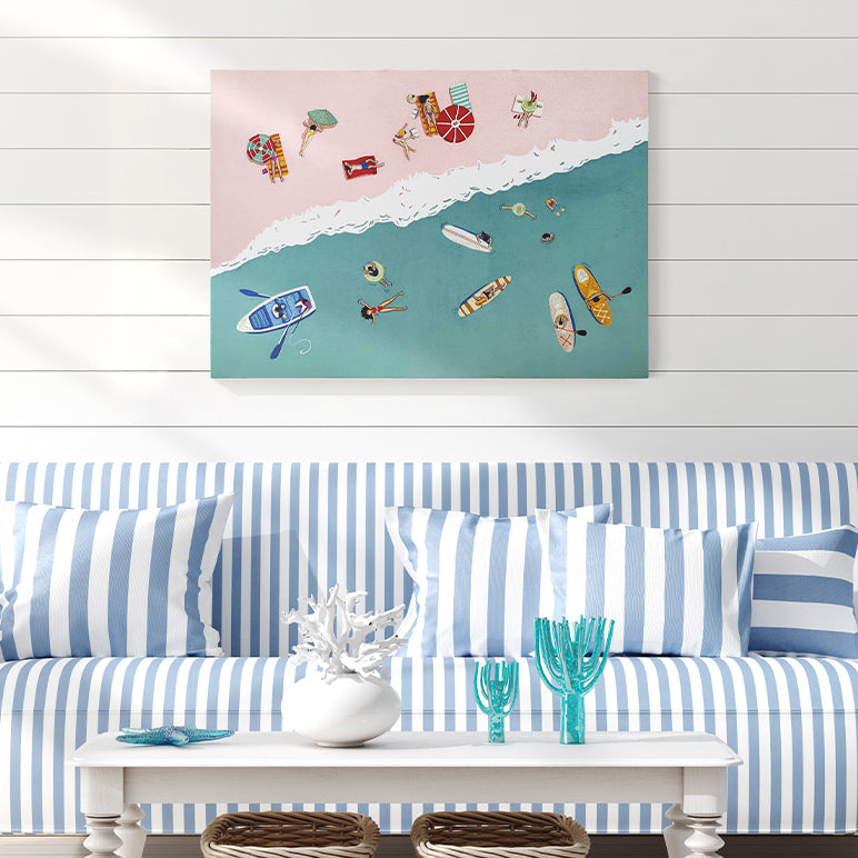 Living room with a blue and white striped sofa, coffee table, and beach-themed wall art.
