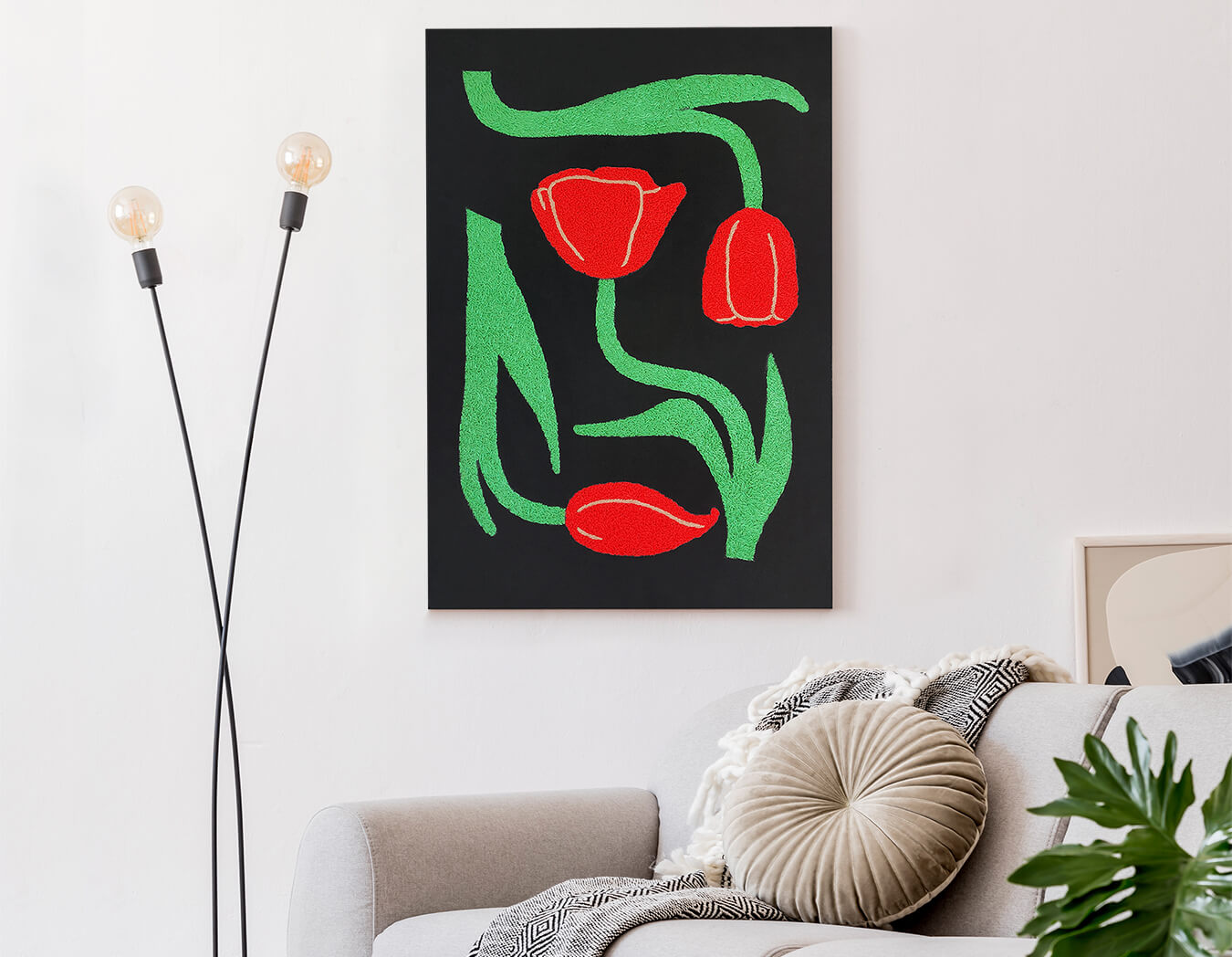 Decorative wall art with red tulips and green leaves on a black background in a living room.