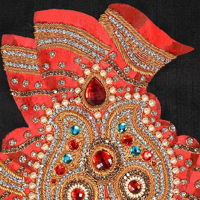 Decorative red and gold hand with gemstones on a black background