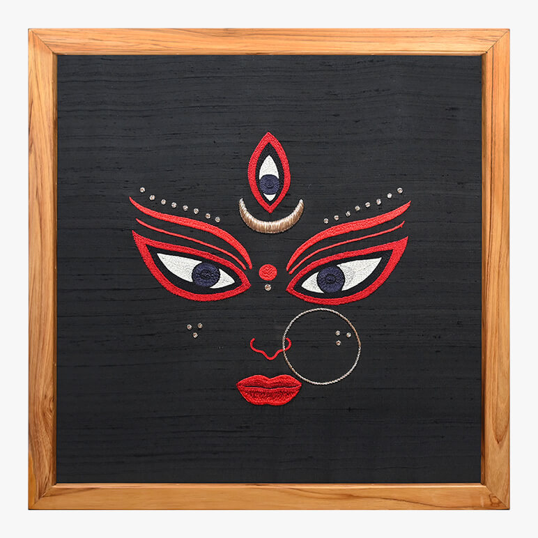 Decorative wall art with a face design on a black background, framed in wood.