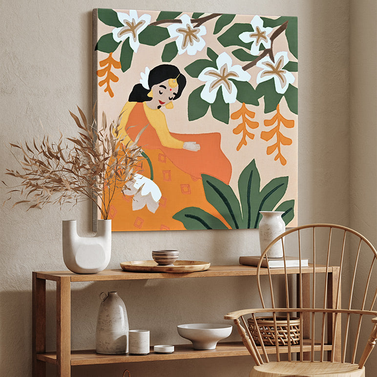 Decorative wall art with a woman and floral elements above a wooden console table with ceramic items.