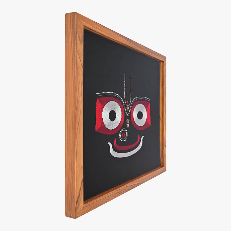 Framed artwork with a stylized face design on a black background