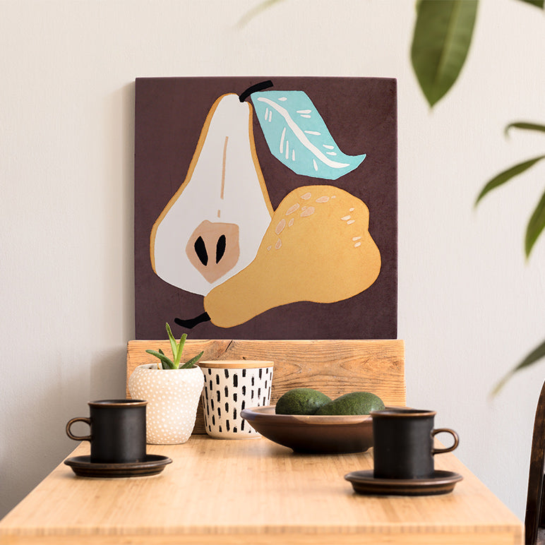 Decorative wall art of a pear on a wooden shelf with cups and plants.