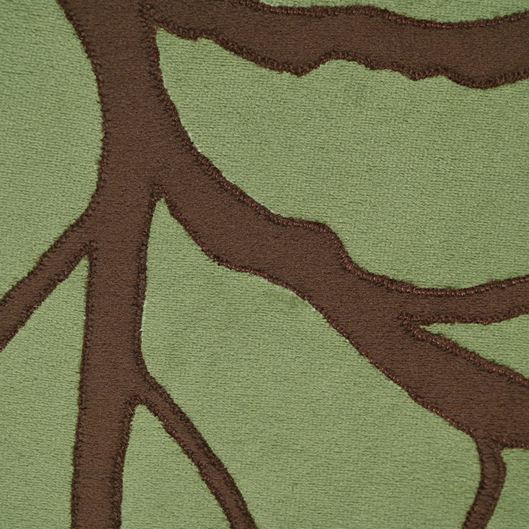 Close-up of a green and brown patterned rug with tree-like design
