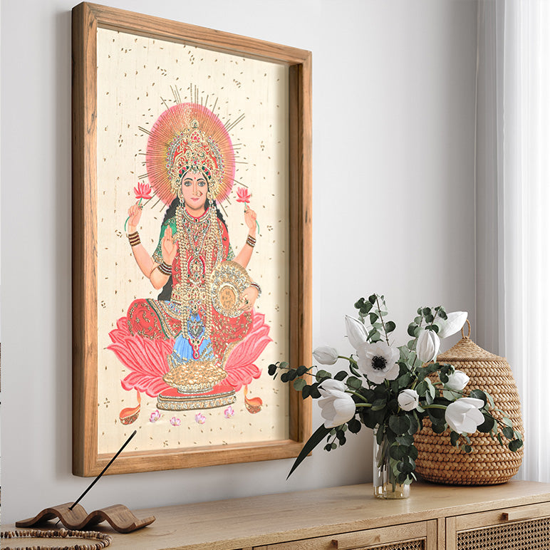 Framed artwork of a deity on a wall with a vase and basket on a table below.