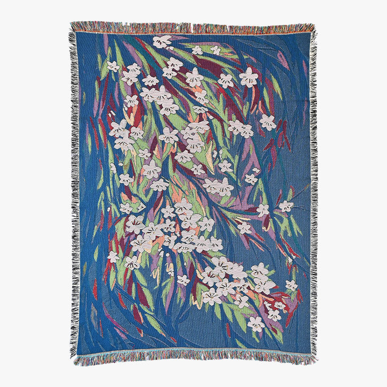 Floral patterned throw blanket with white flowers on a blue background