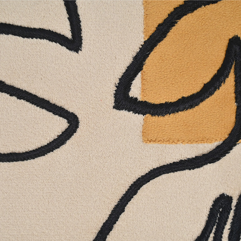 Close-up of a textured rug with abstract patterns in black, beige, and brown.