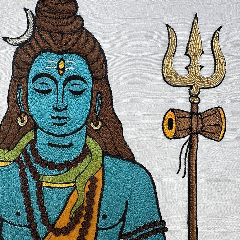 Embroidered detail of a Hindu deity with a trident on a white background