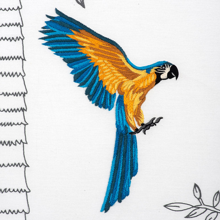Embroidered parrot design on fabric with white background