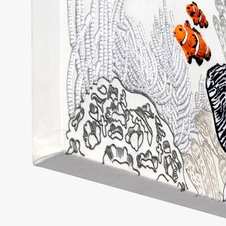 Decorative wall art with black and white patterns and two orange clownfish.