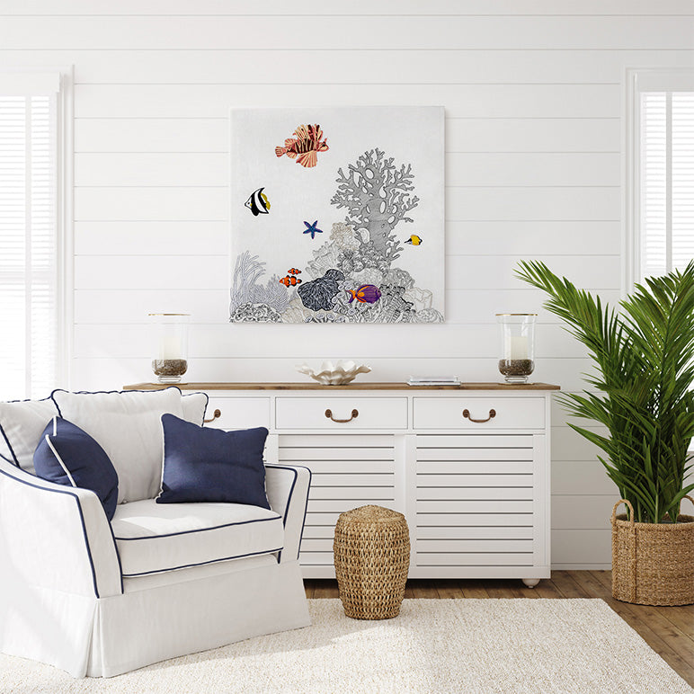 Living room with white armchair, decorative painting of an underwater scene, and a white cabinet.