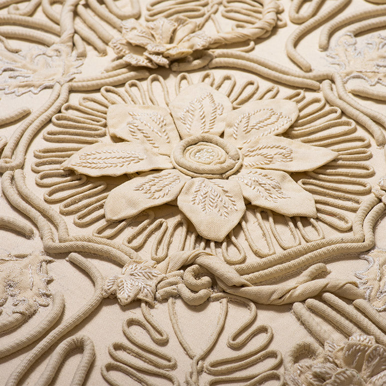 Close-up of a textured beige wall with floral patterns