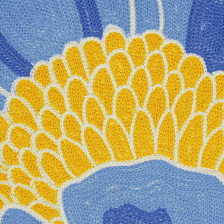 Close-up of a textured yellow flower against a blue background