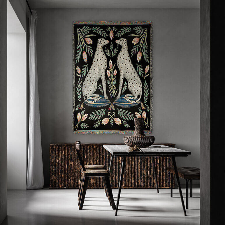 Decorative tapestry with two leopards on a wall above a table in a room.