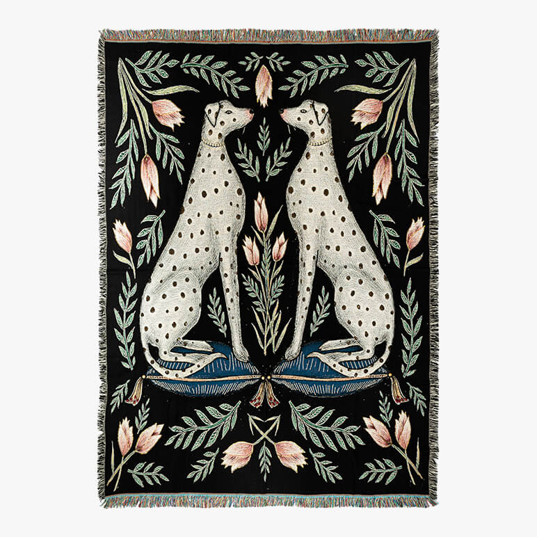 Decorative throw blanket with two dogs and floral patterns on a white background