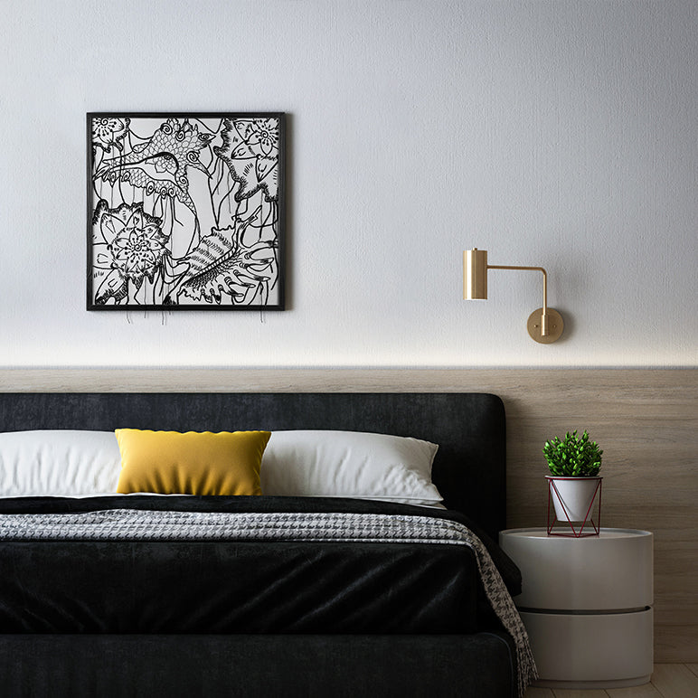 Modern bedroom with black floral wall art, yellow pillow, and white nightstand.