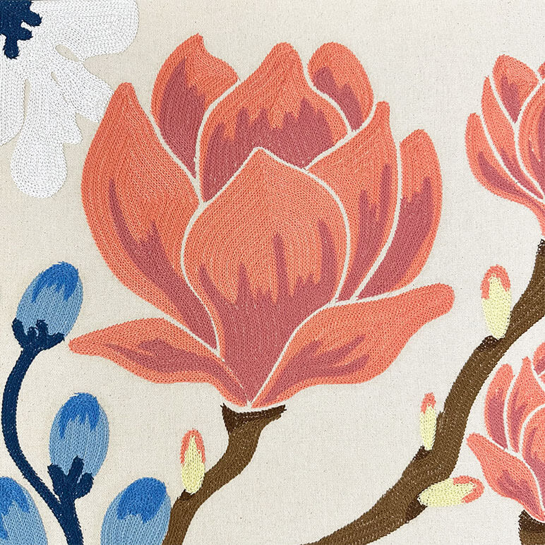 Close-up of a floral design with orange flowers and blue buds on a beige background