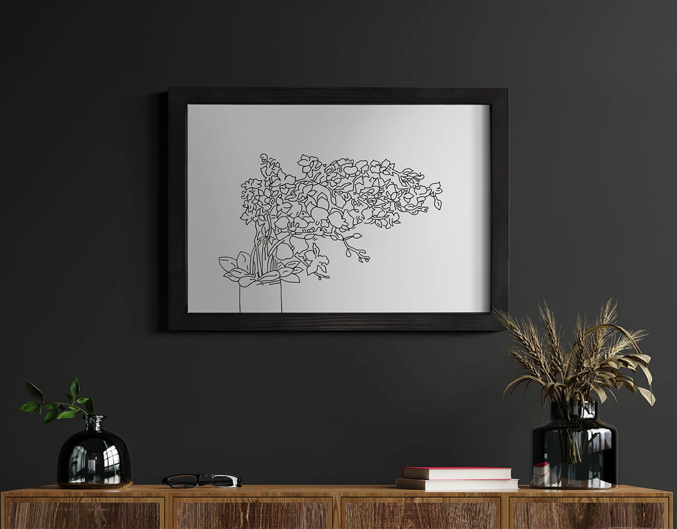 Framed black and white line art of a plant on a dark wall above a wooden console table.
