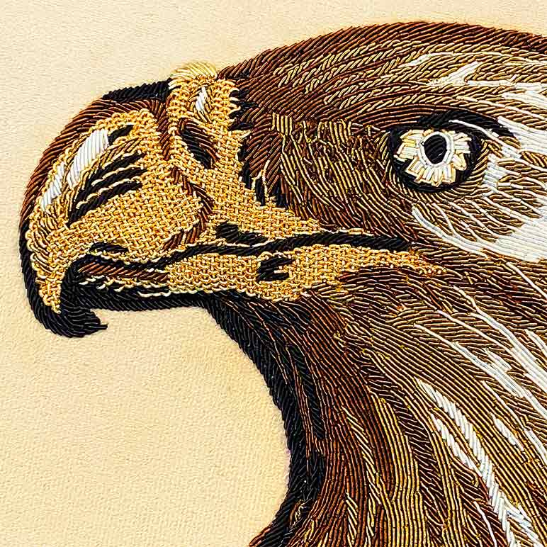 Close-up of an embroidered eagle head on a beige background