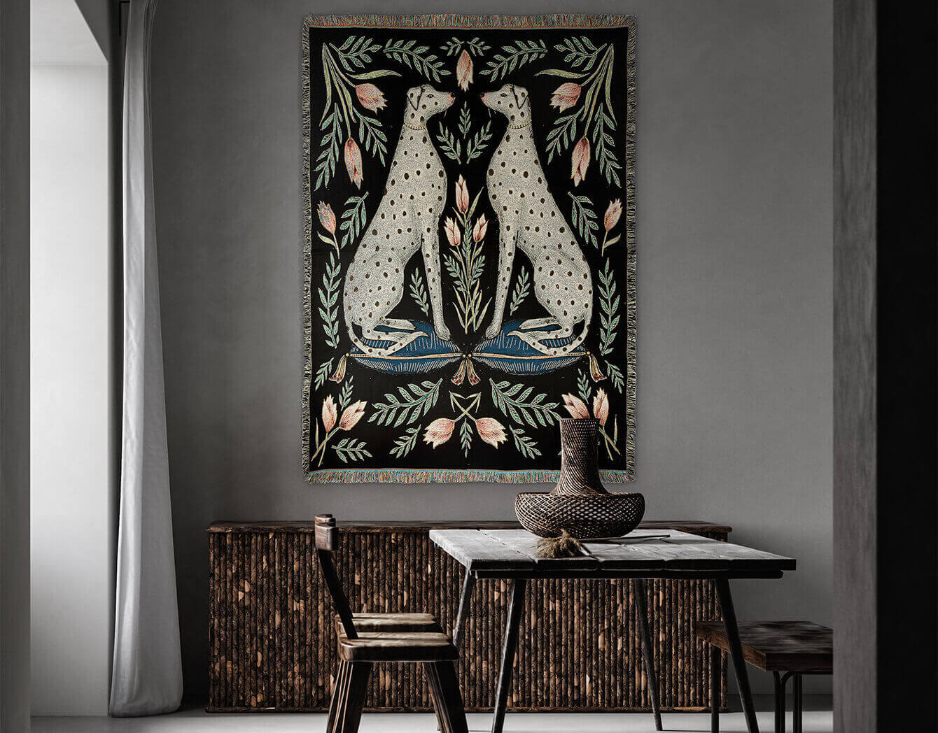 Decorative tapestry with floral and animal design on a wall above a table.