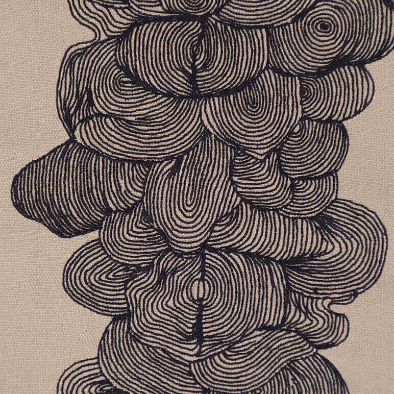 Close-up of an embroidered wall hanging with concentric circular patterns