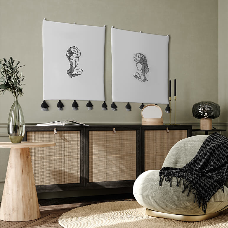 Modern interior with a wooden side table, armchair, and abstract wall art in the form of two embroidered wall hangings.