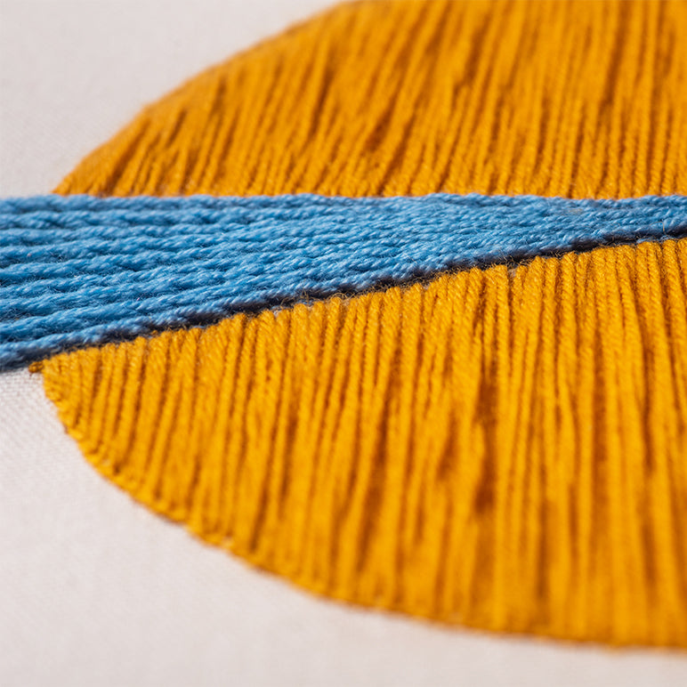 Close-up of yellow fabric with a blue stripe on a white background