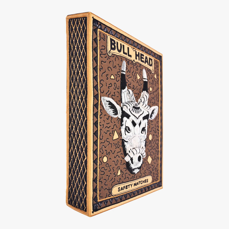 Matchbox with bull head design on a white background