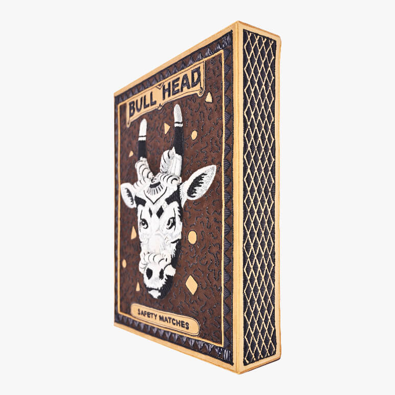 Matchbox with bull head design on a white background