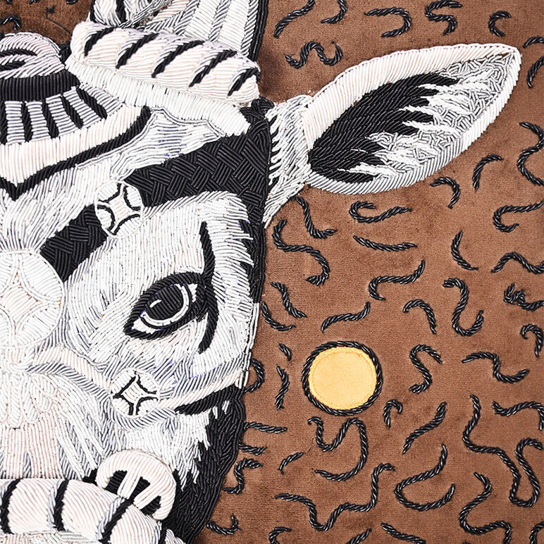 Embroidered design of a zebra on a brown background with black patterns
