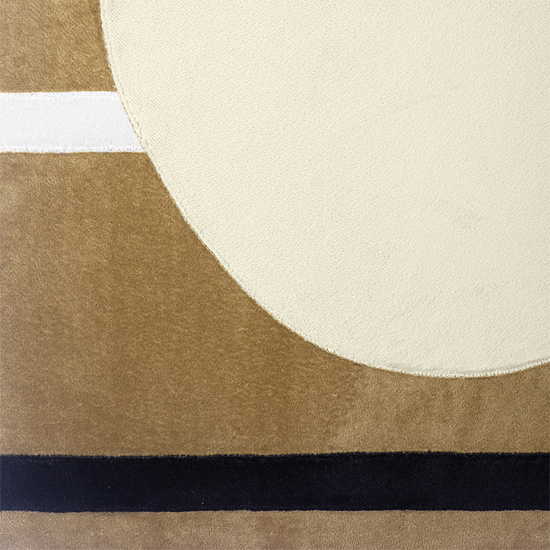 Close-up of a rug with geometric pattern featuring circles and stripes in beige, black, and white.