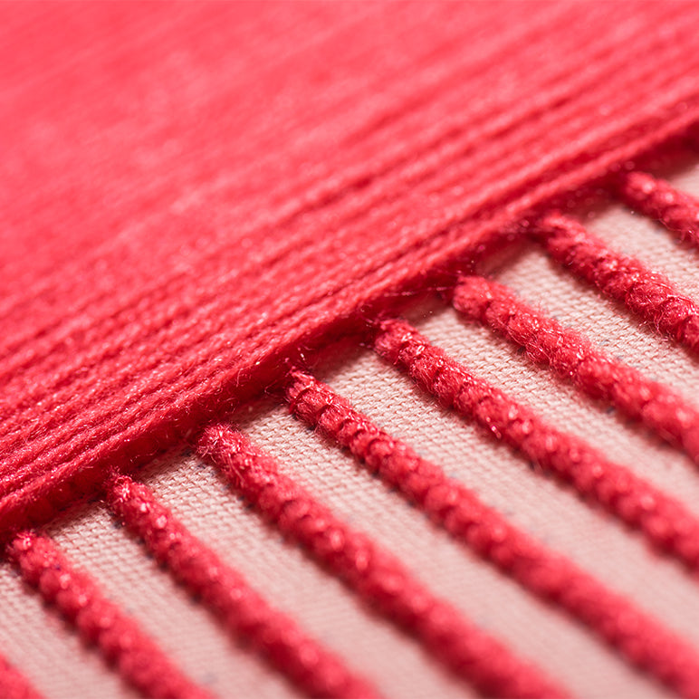 Close-up of red fabric with textured stitching