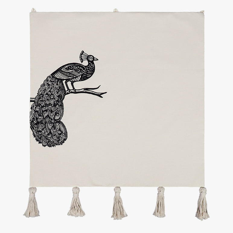 Decorative wall hanging with a black peacock design and tassels on a white background