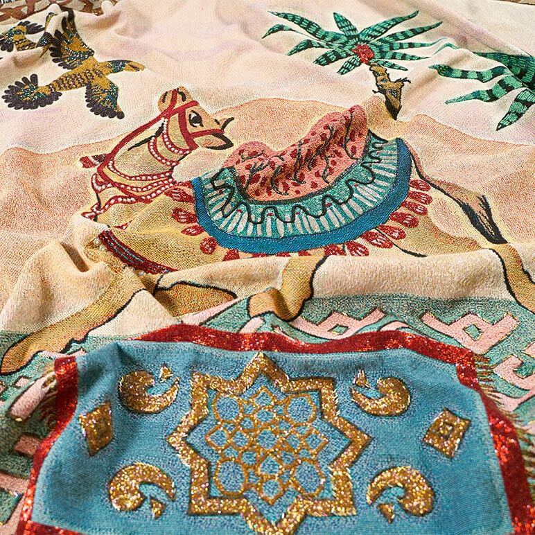 Embellished designer throw blanket showcasing a camel in a gorgeous warm desert background