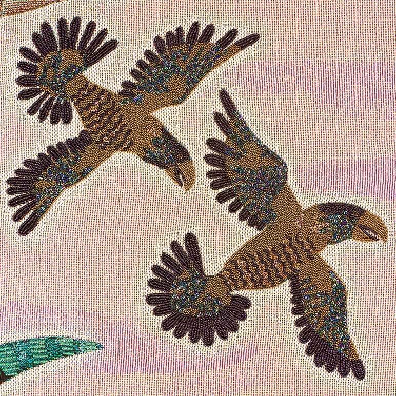 Two beaded eagles on a textured fabric background