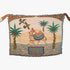 Designer throw blanket with a camel and palm tree design held by two hands.