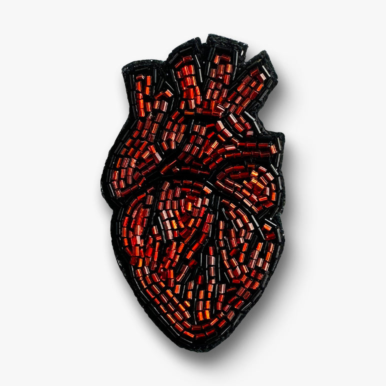 Decorative handmade Heart brooch pin with red and black color on a white background.