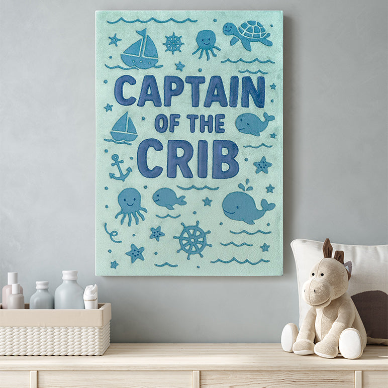 Kids room wall art with Captain of the Crib embroidered along with ocean creatures and displayed in a boy's nursery room
