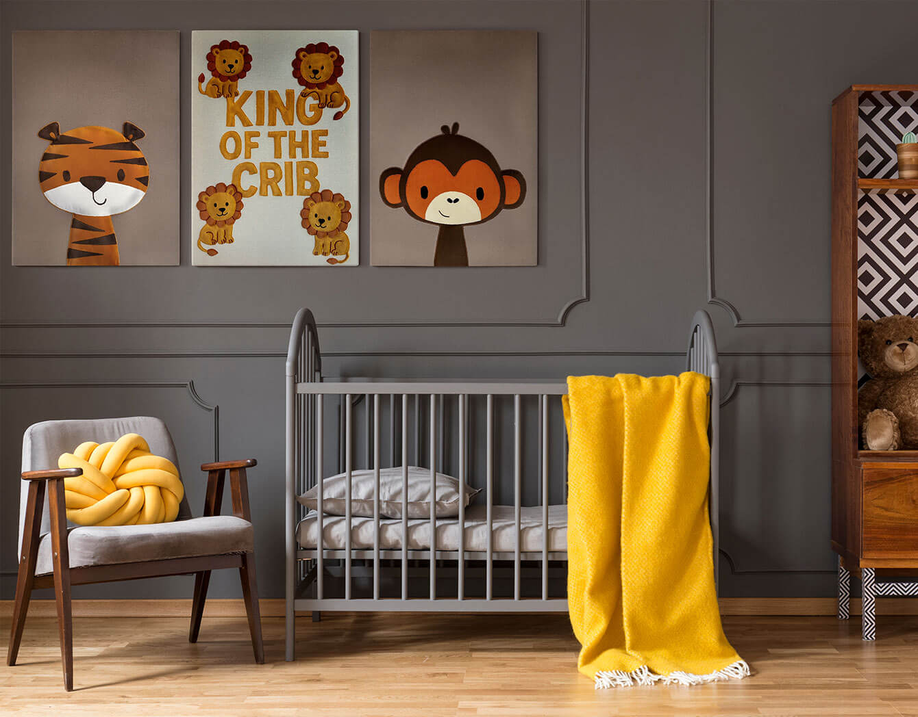 Nursery room with crib, chairs, and wall art featuring animals and text.