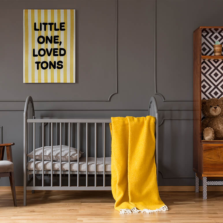 Nursery room with a crib, yellow blanket, and &