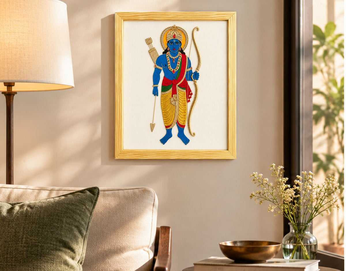 Hand embroidered Rama artwork hung over a wall in a modern living room with a brass vase visible