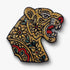 Decorative hand-embroidered Gold tiger head brooch with red and green color on a white background.