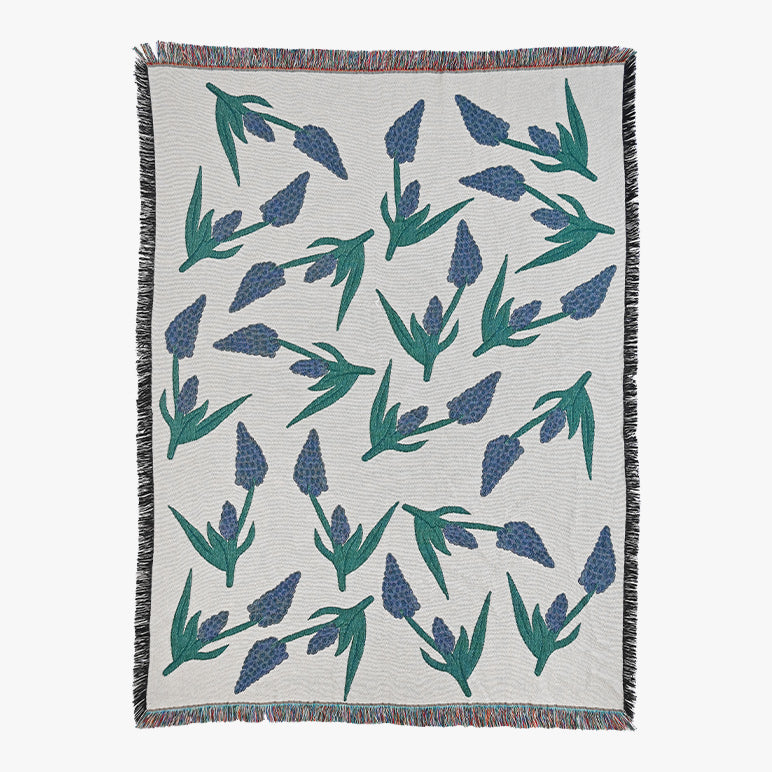 Woven throw blanket with blue floral pattern on a white background