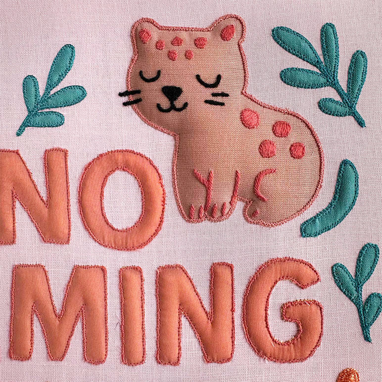 Embroidered design with a cat and typography on a pink background for a nursery room wall art piece