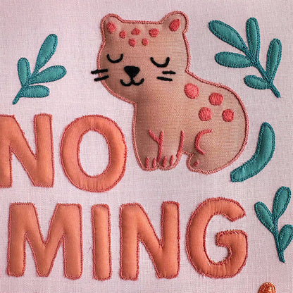 Embroidered design with a cat and typography on a pink background for a nursery room wall art piece