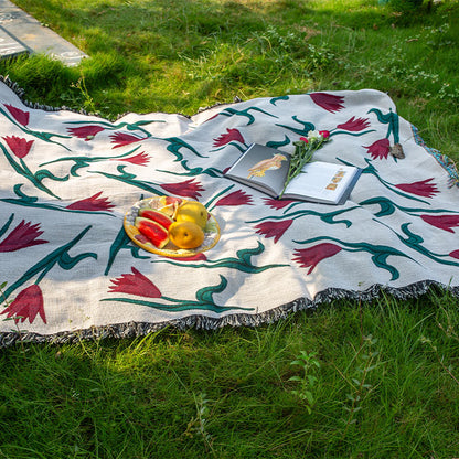 Decorative picnic blanket with floral patterns on grass