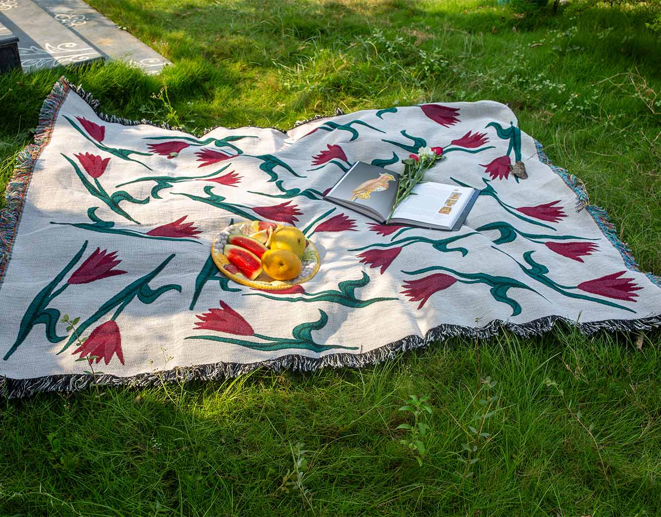 Decorative blanket with floral pattern on grass