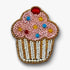 Decorative pink cupcake-shaped brooch pin with beads on a white background