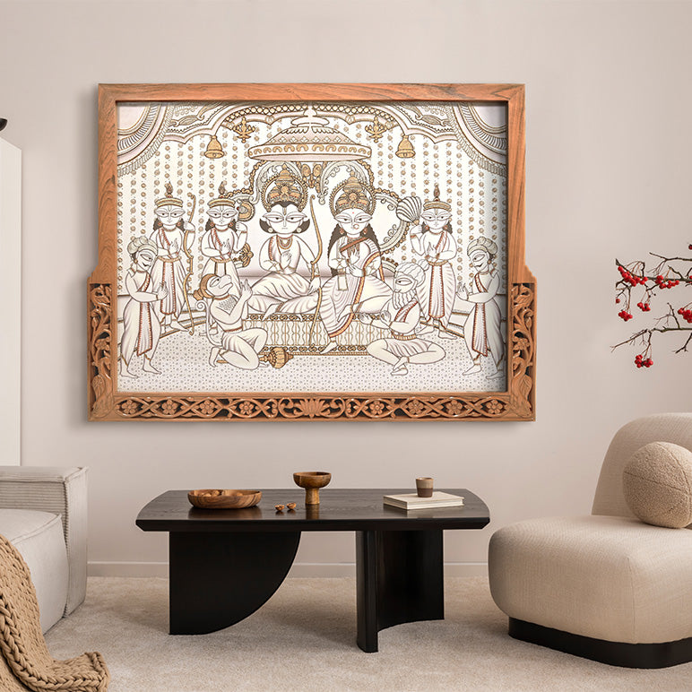Decorative wall art with intricate design in a wooden frame above a coffee table in a living room.
